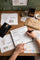 Mobile hero banner showcasing the Molekaus product ideation process. A close-up of a designer's hand sketching initial concepts for our timeless keepsakes on a rustic wooden desk, capturing the authentic craftsmanship behind the brand.