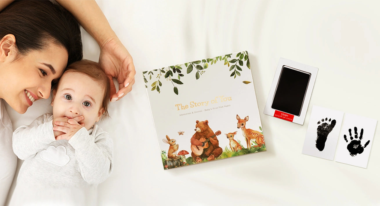 Desktop banner showing a happy mother and newborn baby lying next to the Molekaus premium baby memory book, featuring a mess-free ink pad and footprint keepsake cards.
