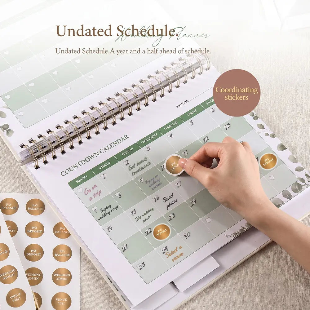 A close-up of a bride applying a 'Dress Fitting' milestone sticker to the monthly calendar inside the Molekaus personalized wedding planner, surrounded by sheets of custom appointment tracking stickers.